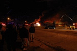 People gathered on the sidewalk in East Spencer to watch the fire in the Dunbar Center Tuesday night. The building used to be a school and several onlookers said they went to school there.