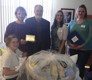 Phillip Barton, Smart Start Rowan board chair, along with Executive Director Amy Brown and Family Support Manager Mary Burridge, far right, present a gift basket to  Holly Schenck, Josh Young and their newborn son, Blake. He was the first baby born at Novant Health Rowan Medical Center in 2015.