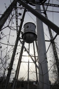 The water tanks, which have the words "N.C. Finishing Company" on them, rise above the debris at the former Color-Tex plant site.