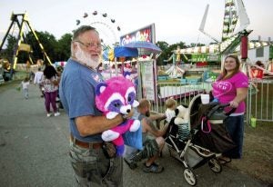 JON C. LAKEY / SALISBURY POST Allen Leonard holds onto a pink raccoon stuffed animal that he won at one of the carnival games. The Rowan County Fair continues to the enjoyment of fairgoers who came to take in the food, rides and sights. Thursday, September 29, 2016, in Salisbury, N.C.